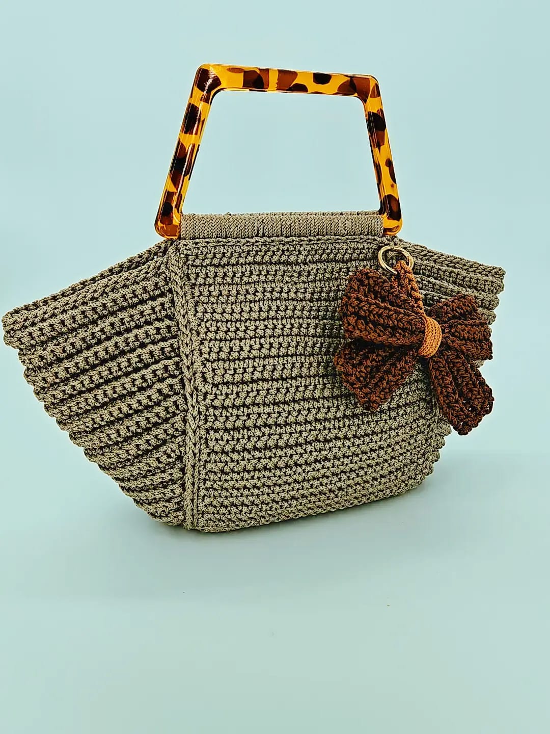 Bolso tejido a crochet con asas de carey y lazo decorativo