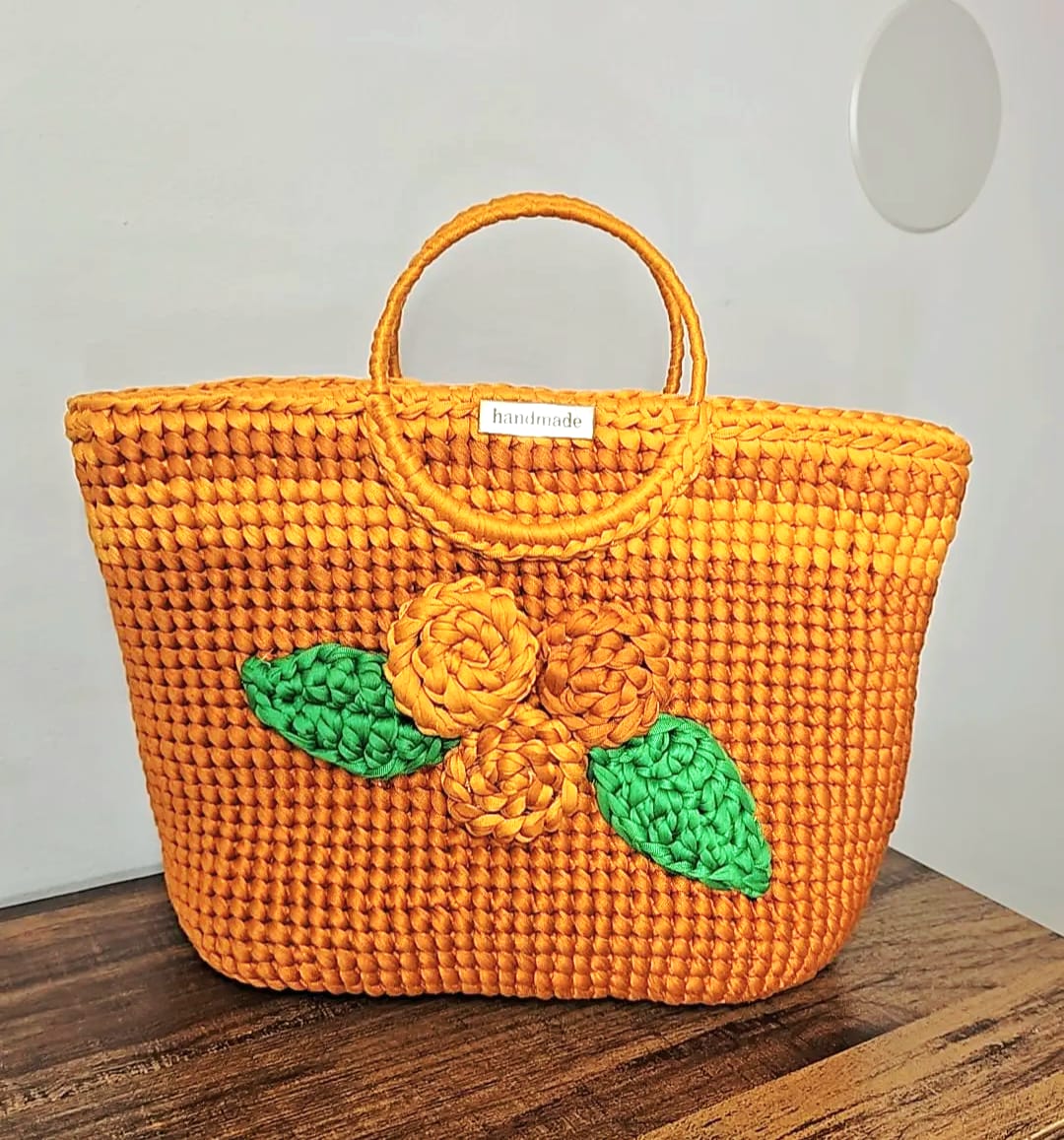 Bolso tejido a crochet color naranja con flores decorativas